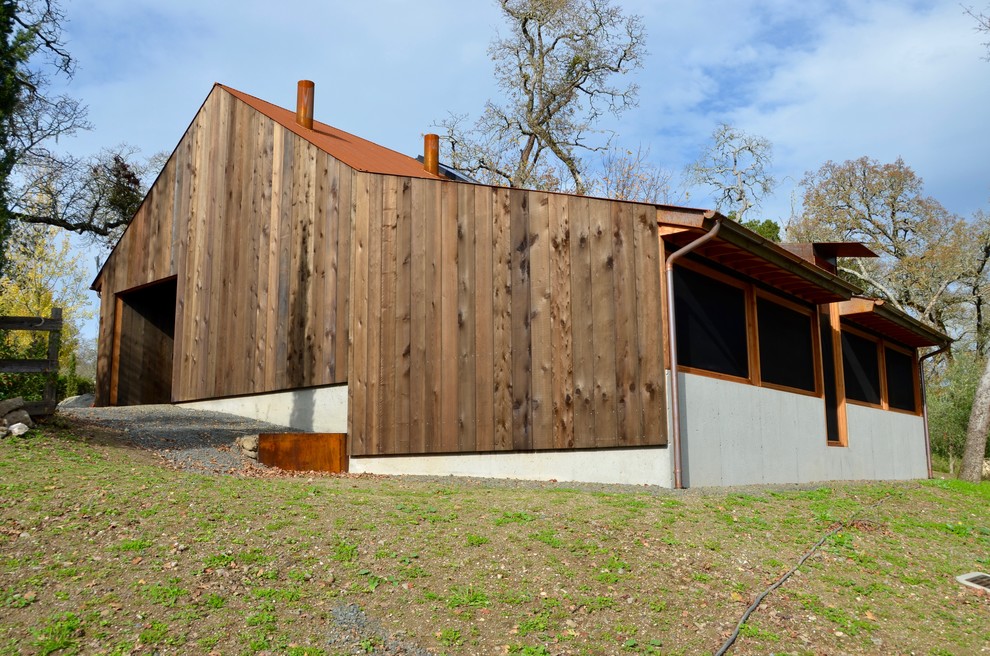 Inspiration for a country exterior in San Francisco with wood siding, a gable roof and a metal roof.