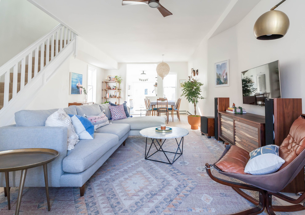 Living room - mid-sized scandinavian open concept light wood floor living room idea in New York with white walls and a wall-mounted tv
