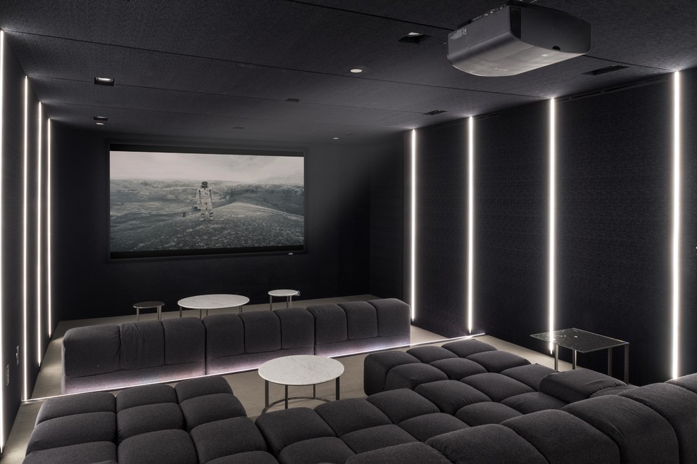 This is an example of a contemporary enclosed home theatre in Los Angeles with black walls, carpet, a projector screen and beige floor.