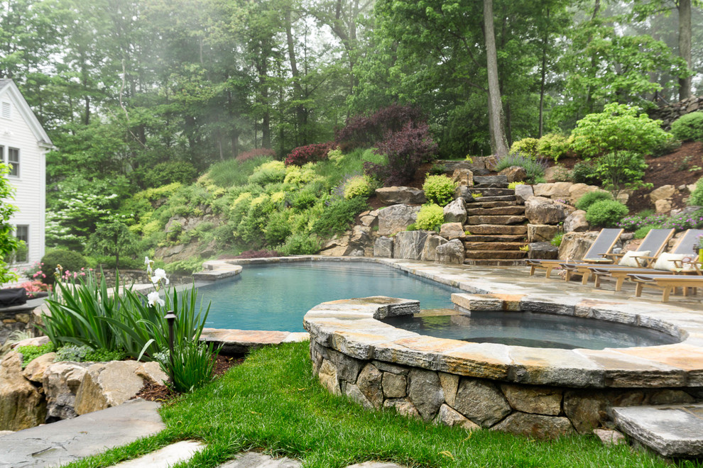 Expansive traditional backyard custom-shaped natural pool in New York with a hot tub and natural stone pavers.