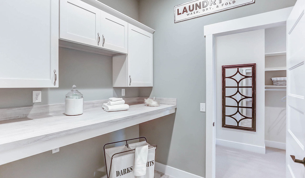 This is an example of a large country single-wall dedicated laundry room in Other with white cabinets, laminate benchtops, blue walls, ceramic floors, a side-by-side washer and dryer, grey floor and grey benchtop.