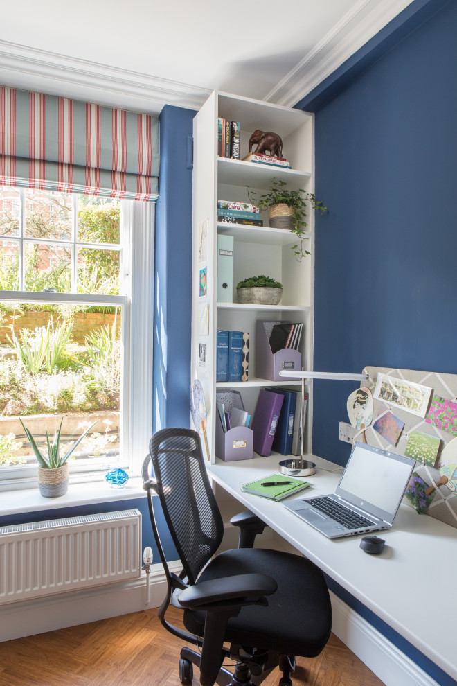 Foto de despacho contemporáneo pequeño sin chimenea con paredes azules, suelo de bambú, escritorio empotrado, suelo marrón y bandeja