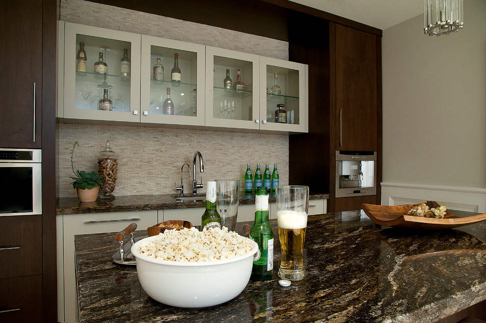 This is an example of a transitional single-wall wet bar in Toronto with an undermount sink, flat-panel cabinets, medium wood cabinets, granite benchtops, beige splashback, mosaic tile splashback and limestone floors.
