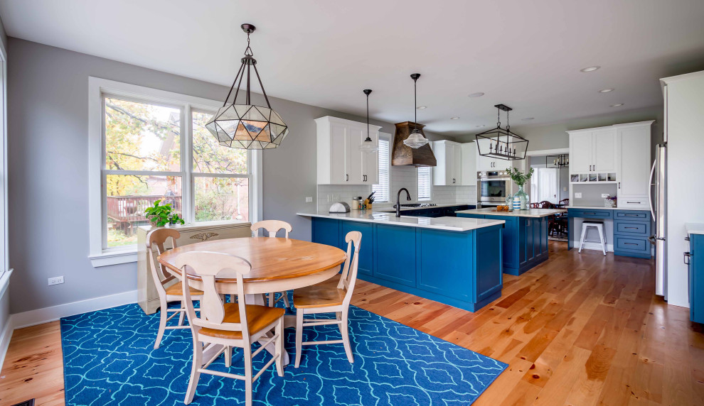 Large cottage l-shaped light wood floor, brown floor and wallpaper ceiling eat-in kitchen photo in Chicago with a farmhouse sink, shaker cabinets, turquoise cabinets, marble countertops, white backsplash, porcelain backsplash, stainless steel appliances, an island and multicolored countertops