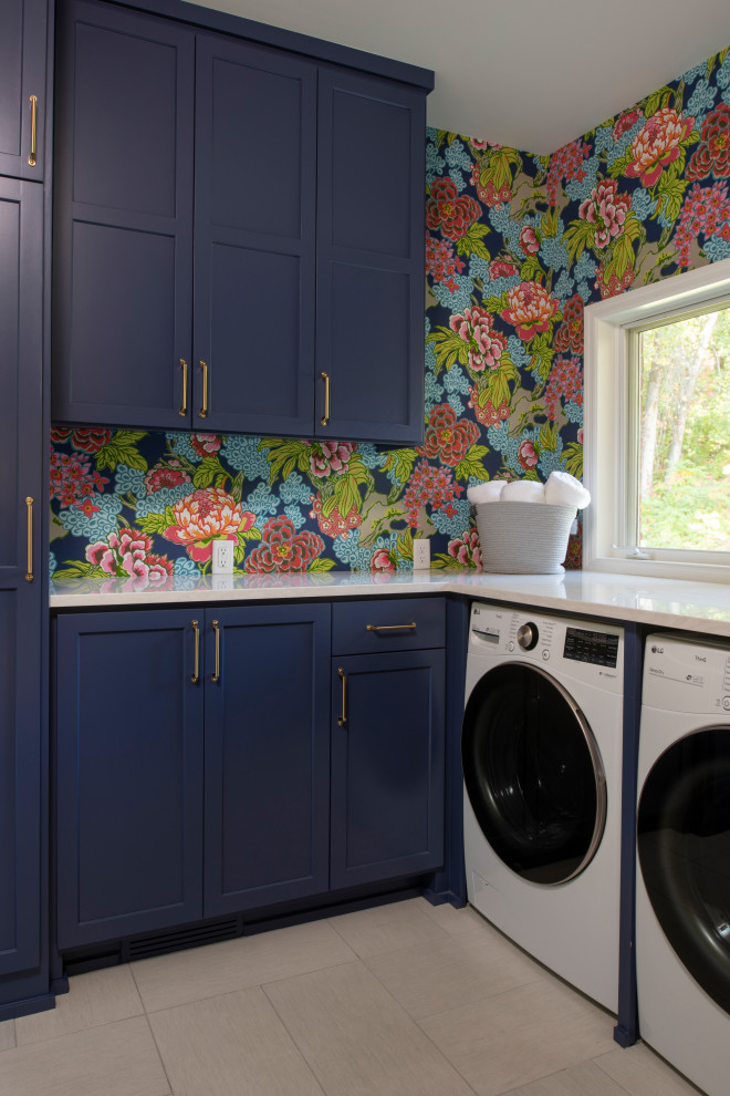 Foto de lavadero clásico con fregadero bajoencimera, puertas de armario azules, encimera de cuarzo compacto, suelo de baldosas de porcelana, lavadora y secadora juntas, encimeras blancas y papel pintado