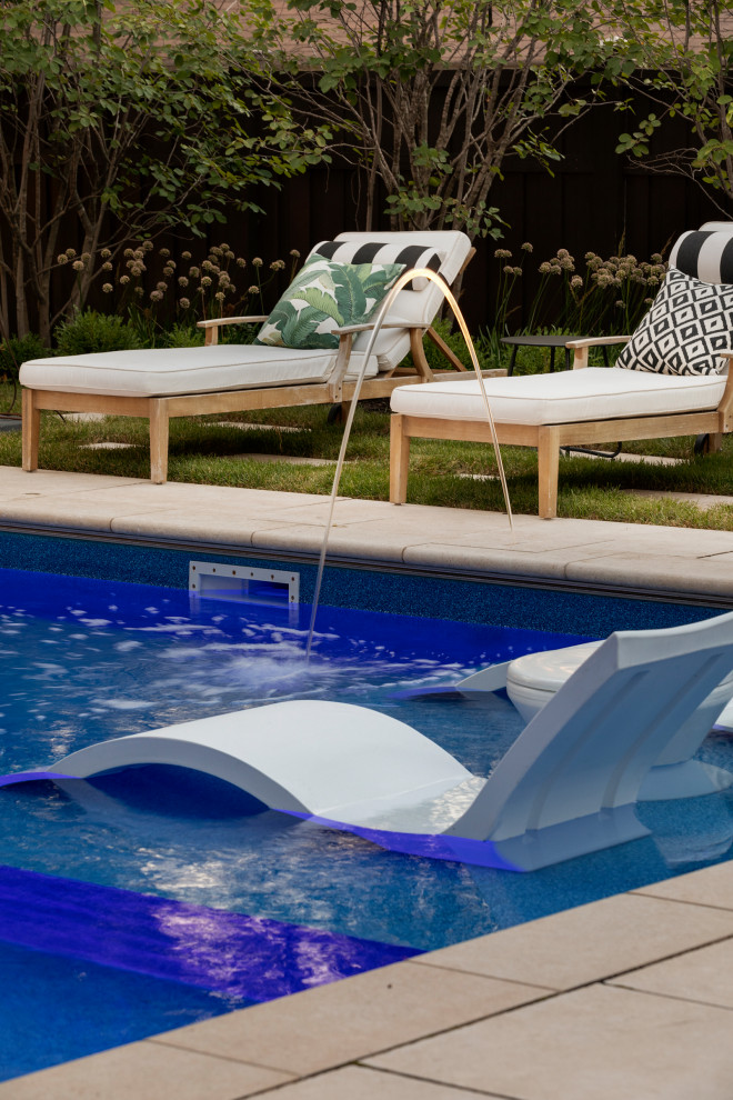 Ejemplo de piscina natural de estilo americano grande rectangular en patio trasero con paisajismo de piscina y adoquines de piedra natural