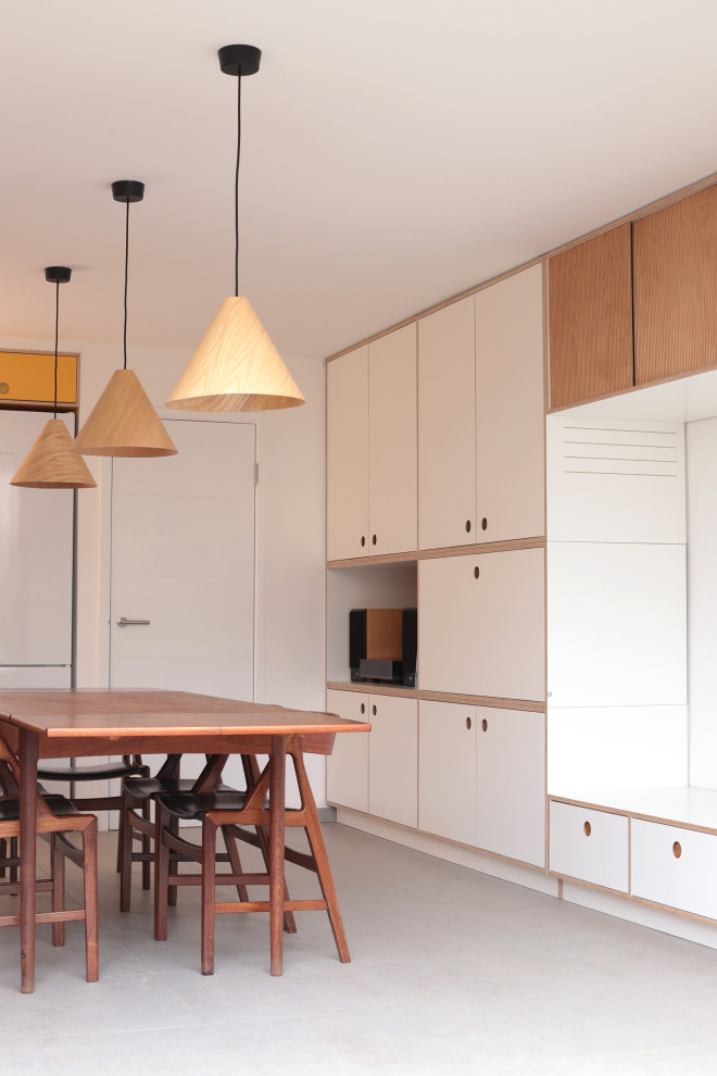 Large contemporary single-wall eat-in kitchen in London with white cabinets, laminate benchtops, yellow splashback, ceramic splashback, black appliances, no island, grey floor and grey benchtop.