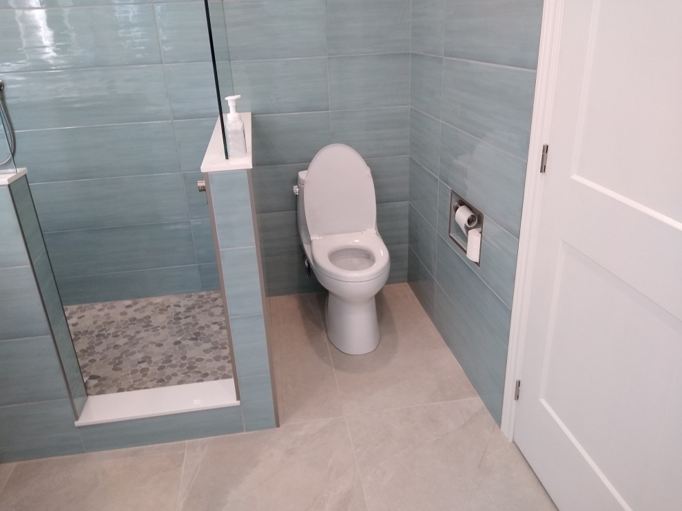 Photo of a mid-sized contemporary master bathroom in Toronto with shaker cabinets, light wood cabinets, a freestanding tub, a corner shower, a one-piece toilet, blue tile, porcelain tile, blue walls, porcelain floors, an undermount sink, engineered quartz benchtops, beige floor, an open shower, white benchtops, a niche, a double vanity and a freestanding vanity.
