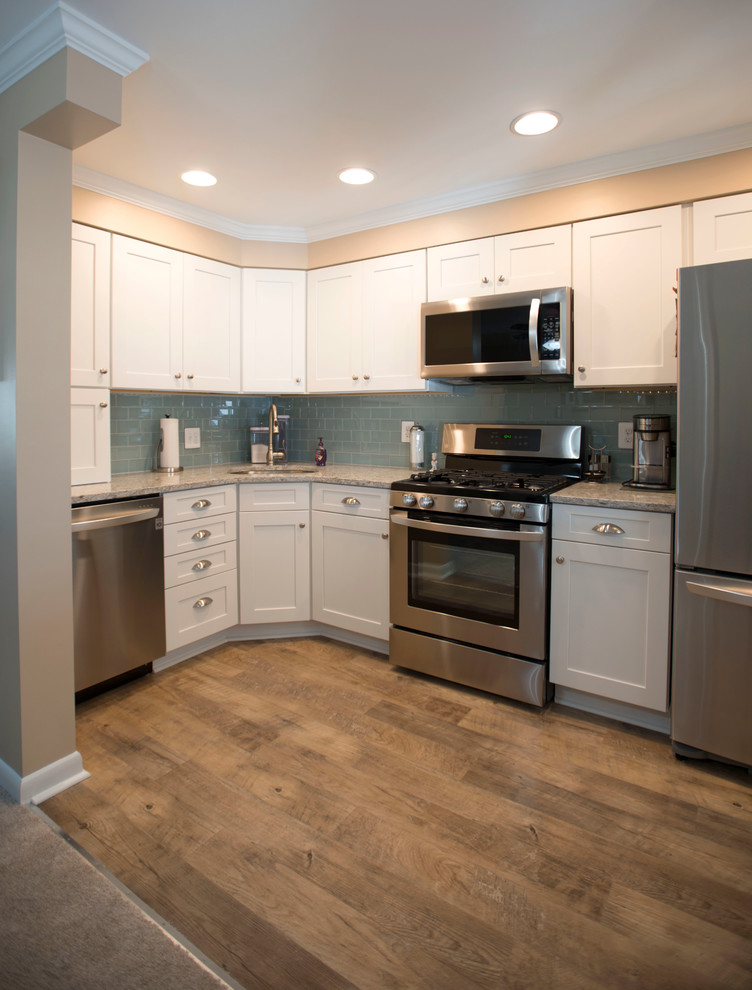 Example of a small transitional l-shaped vinyl floor enclosed kitchen design in Baltimore with an undermount sink, shaker cabinets, white cabinets, granite countertops, blue backsplash, glass tile backsplash, stainless steel appliances and no island