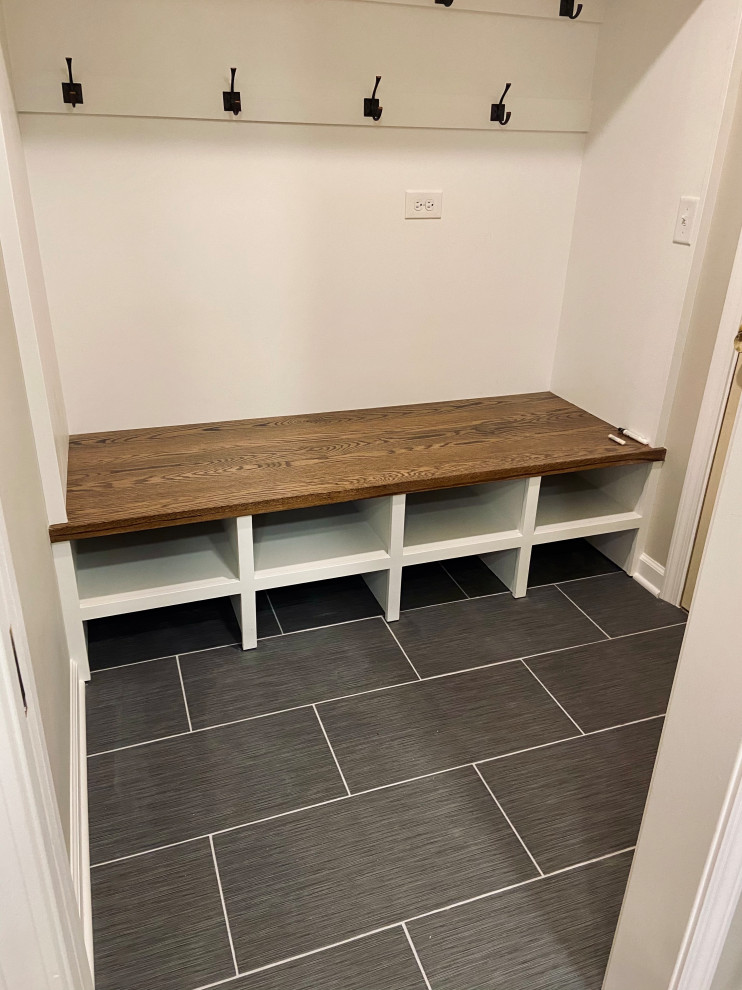 Photo of a small modern boot room in Chicago with beige walls, ceramic flooring, a single front door and black floors.