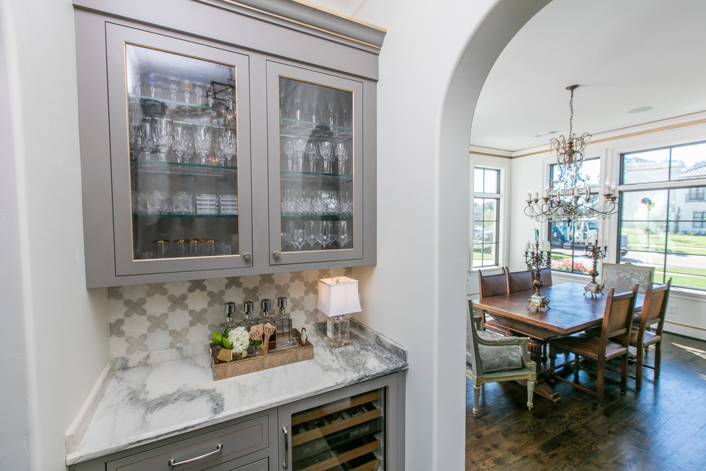 Inspiration for a small contemporary single-wall wet bar in Dallas with shaker cabinets, grey cabinets, marble benchtops, grey splashback, stone slab splashback and dark hardwood floors.