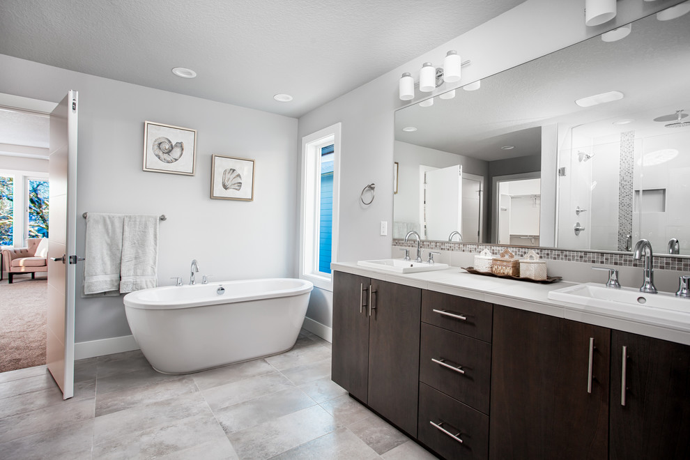 This is an example of a large modern master bathroom in Portland with flat-panel cabinets, dark wood cabinets, a claw-foot tub, a double shower, a two-piece toilet, white tile, glass tile, grey walls, ceramic floors, a drop-in sink, tile benchtops, grey floor and a hinged shower door.