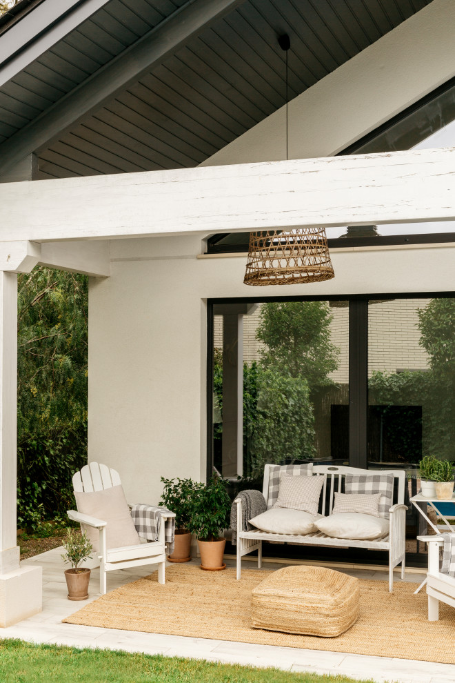 Foto de terraza escandinava de tamaño medio en patio trasero y anexo de casas con suelo de baldosas