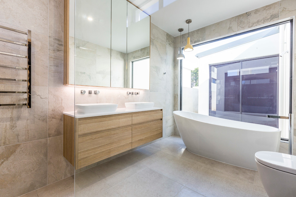 Design ideas for a mid-sized contemporary master bathroom in Gold Coast - Tweed with raised-panel cabinets, light wood cabinets, a freestanding tub, an open shower, a wall-mount toilet, porcelain tile, porcelain floors, a trough sink and engineered quartz benchtops.