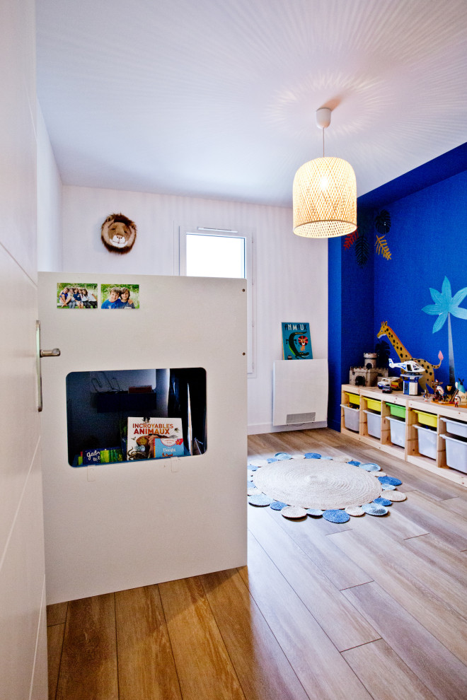 Idées déco pour une grande chambre d'enfant de 4 à 10 ans contemporaine avec un mur bleu, sol en stratifié et un sol marron.