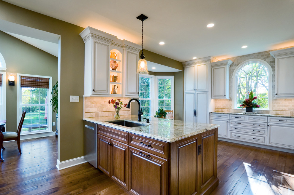 Inspiration for a large traditional u-shaped eat-in kitchen in Philadelphia with raised-panel cabinets, white cabinets, granite benchtops, beige splashback, stainless steel appliances, medium hardwood floors and multiple islands.