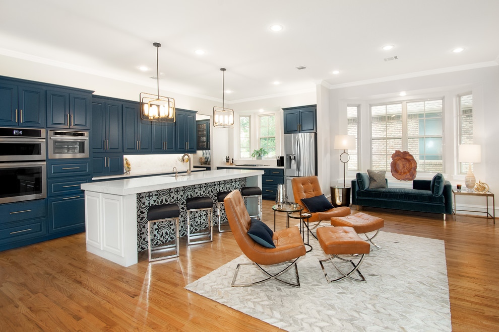 Example of a large transitional single-wall medium tone wood floor and brown floor open concept kitchen design in Dallas with a single-bowl sink, flat-panel cabinets, blue cabinets, quartz countertops, white backsplash, marble backsplash, stainless steel appliances, an island and white countertops