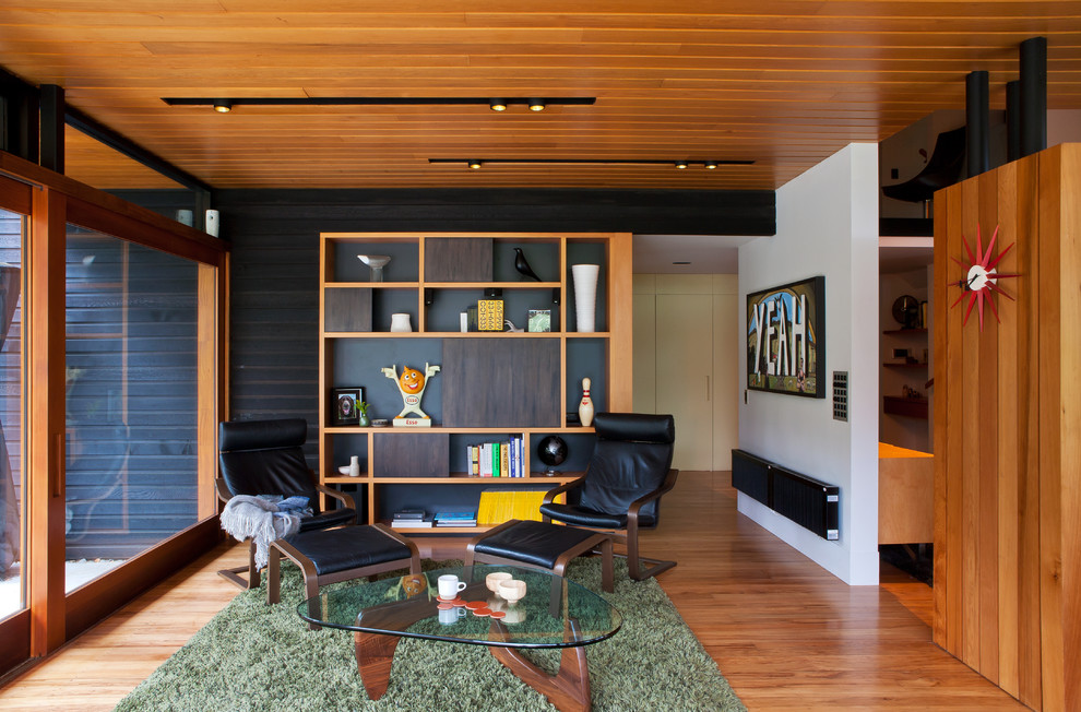 Photo of a midcentury living room in Auckland with light hardwood floors.