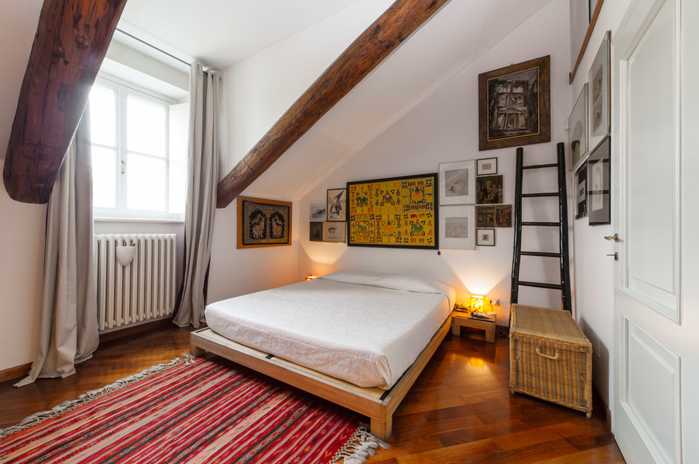 Design ideas for an eclectic bedroom in Turin with white walls, dark hardwood floors and brown floor.