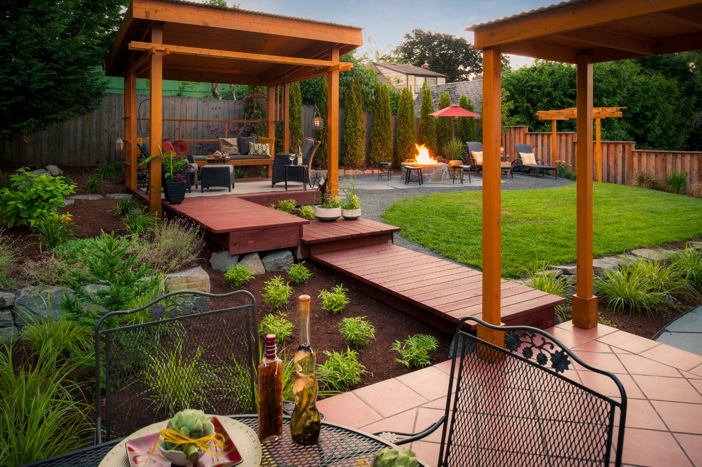 This is an example of a mid-sized traditional backyard deck in Portland with a fire feature.