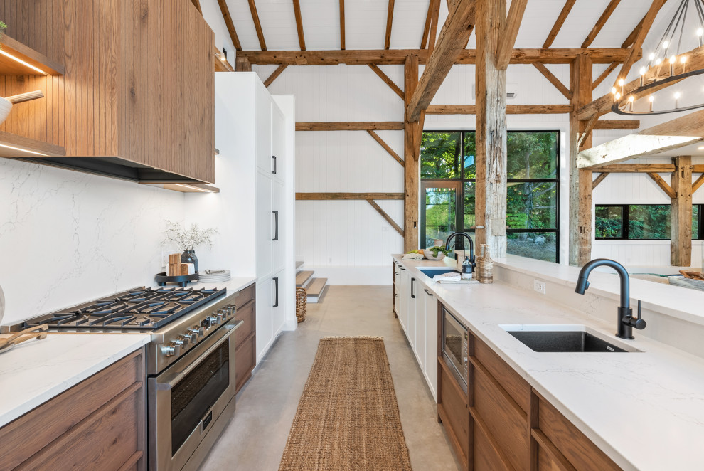 Inspiration for a large transitional galley eat-in kitchen remodel with an undermount sink, shaker cabinets, white cabinets, quartz countertops, white backsplash, quartz backsplash, paneled appliances, an island and white countertops