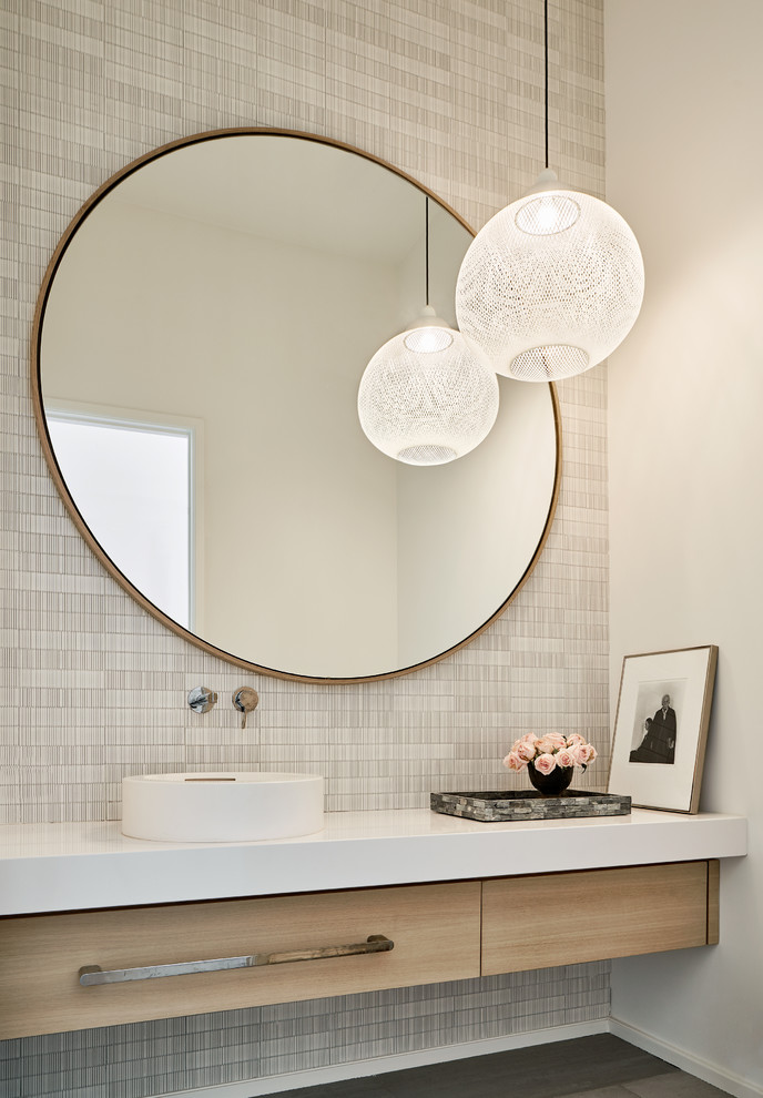 Mid-sized contemporary powder room in Dallas with flat-panel cabinets, light wood cabinets, porcelain floors, a vessel sink, engineered quartz benchtops, white benchtops, grey walls and grey floor.