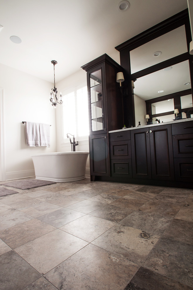 Inspiration for a large traditional master bathroom in Indianapolis with raised-panel cabinets, dark wood cabinets, a freestanding tub, granite benchtops and white benchtops.