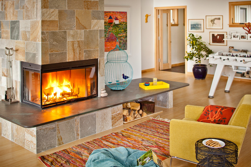 This is an example of a contemporary family room in Portland Maine with a corner fireplace.