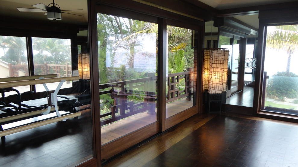This is an example of a small asian home yoga studio in Miami with dark hardwood floors.