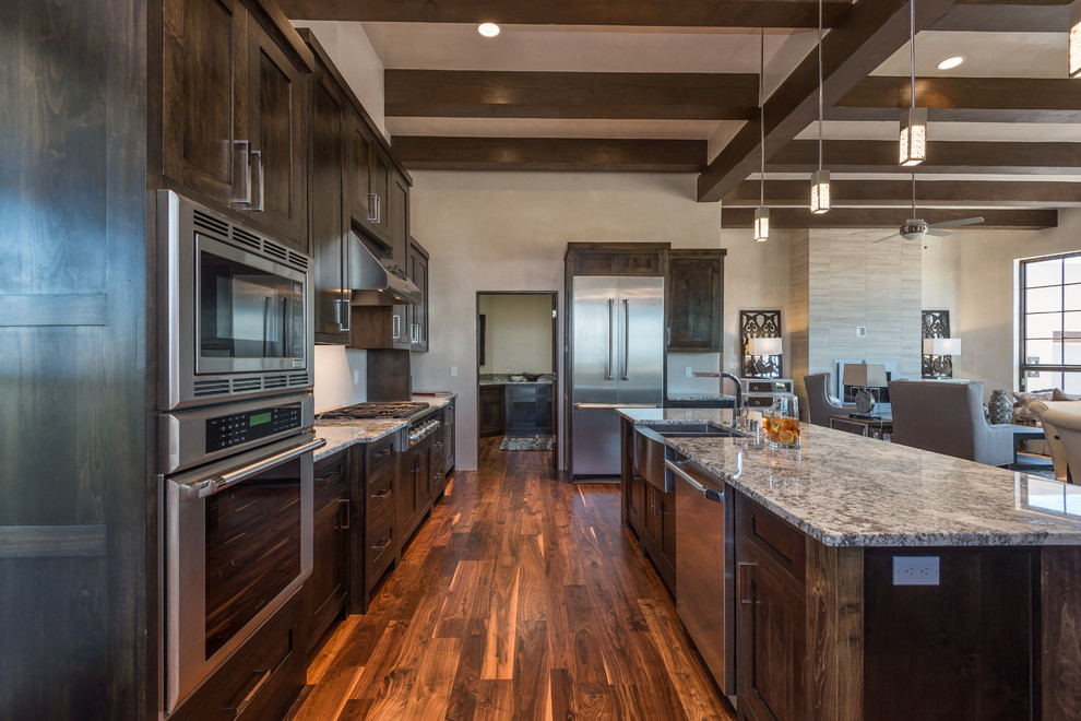 Large transitional single-wall dark wood floor eat-in kitchen photo in Albuquerque with a double-bowl sink, shaker cabinets, dark wood cabinets, granite countertops, beige backsplash, stainless steel appliances and an island