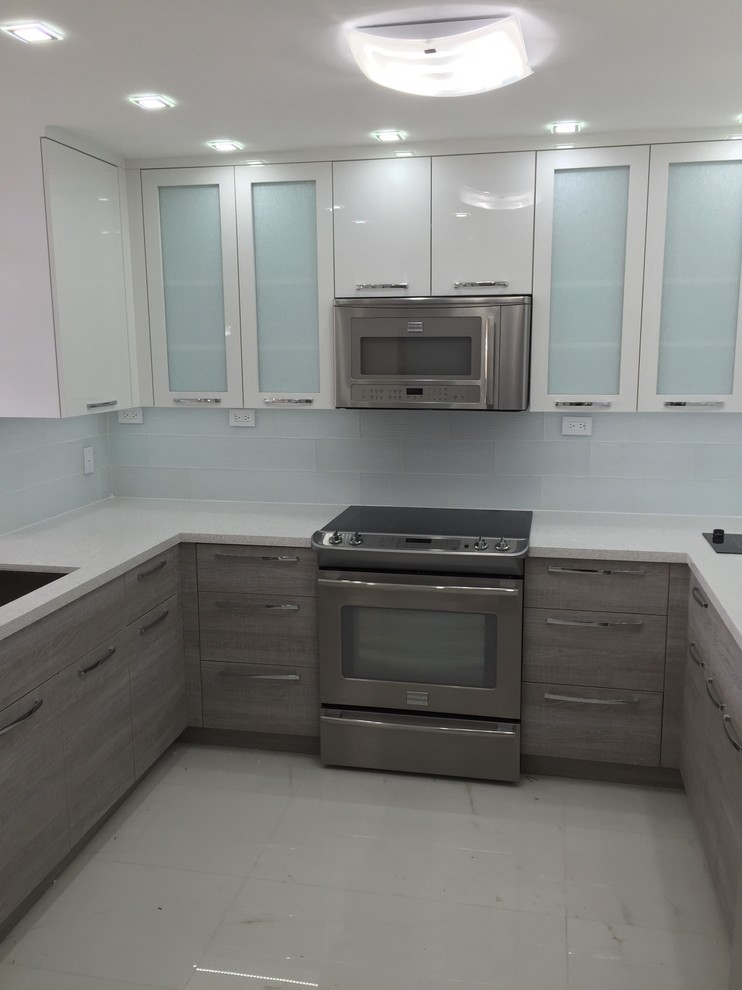 Photo of a mid-sized contemporary u-shaped separate kitchen in Miami with an undermount sink, flat-panel cabinets, grey cabinets, recycled glass benchtops, white splashback, glass tile splashback, stainless steel appliances, marble floors and no island.