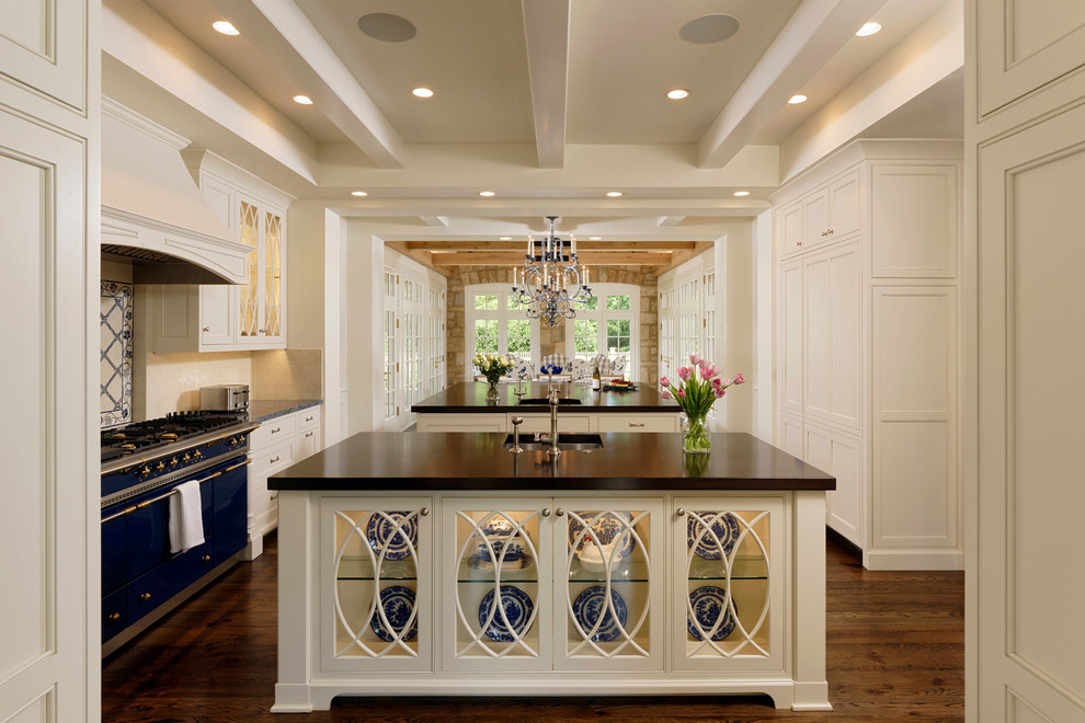 This is an example of a traditional kitchen in DC Metro with an undermount sink, glass-front cabinets, beige cabinets, beige splashback, coloured appliances, medium hardwood floors and multiple islands.
