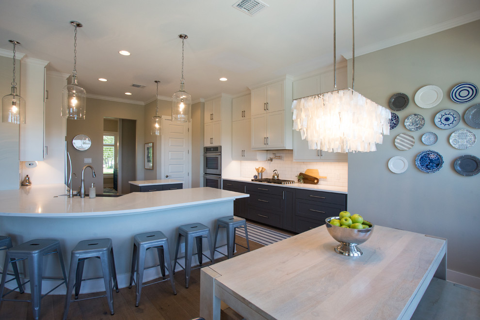 Example of a transitional light wood floor and beige floor eat-in kitchen design in Austin with a farmhouse sink, shaker cabinets, white cabinets, quartz countertops, white backsplash, subway tile backsplash, stainless steel appliances and an island