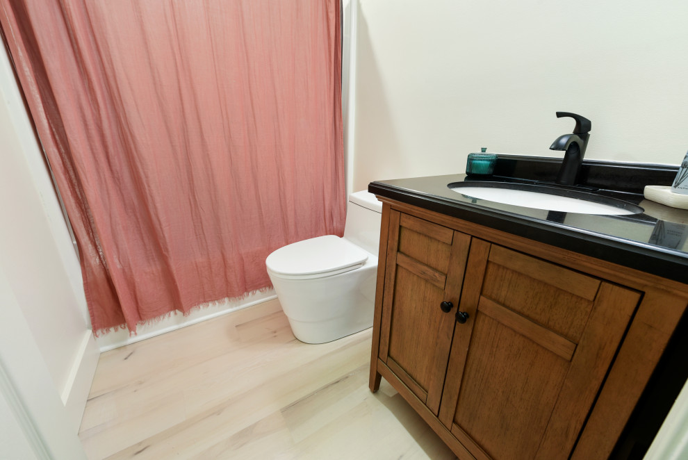Idee per una stanza da bagno minimalista di medie dimensioni con ante a filo, ante marroni, vasca ad angolo, bidè, pareti bianche, pavimento in vinile, lavabo da incasso, top in marmo, pavimento beige, top nero, un lavabo e mobile bagno incassato
