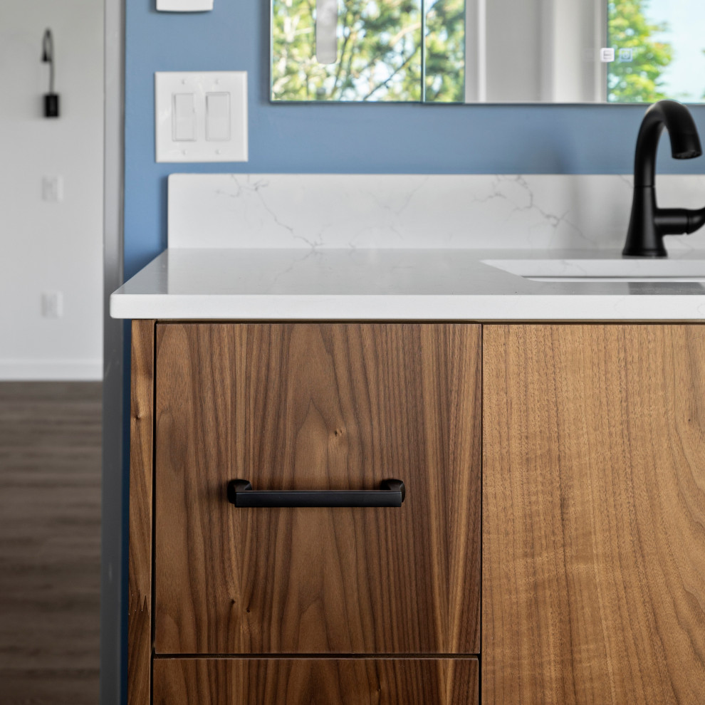 Inspiration for a large transitional single-wall vinyl floor, brown floor and vaulted ceiling open concept kitchen remodel in Seattle with an undermount sink, shaker cabinets, white cabinets, quartz countertops, white backsplash, quartz backsplash, stainless steel appliances, an island and white countertops