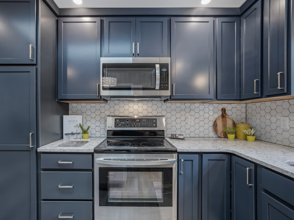 Inspiration for a large transitional l-shaped kitchen remodel in Raleigh with an undermount sink, recessed-panel cabinets, quartz countertops, porcelain backsplash, stainless steel appliances and an island
