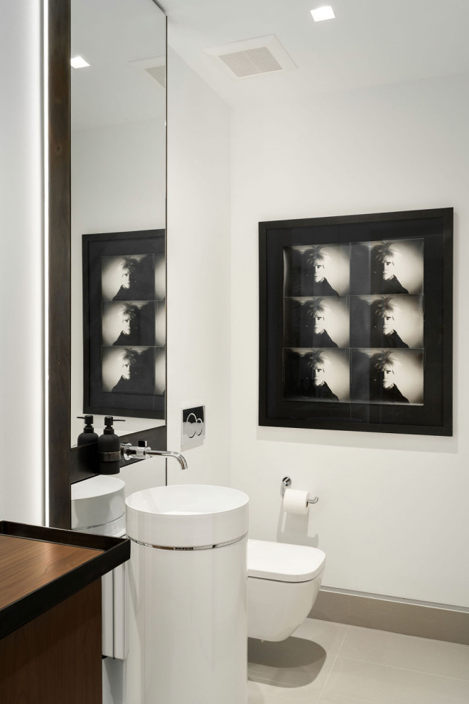 Immagine di un bagno di servizio design di medie dimensioni con WC sospeso, pareti bianche, pavimento in gres porcellanato, lavabo a colonna e top in legno