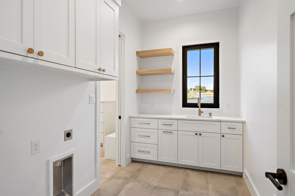 Photo of a rural l-shaped utility room in Austin with a submerged sink, shaker cabinets, white cabinets, white walls, light hardwood flooring, a side by side washer and dryer and white worktops.