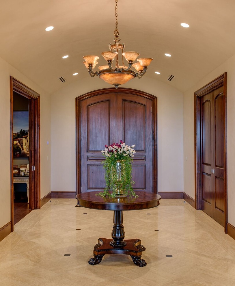Mid-sized traditional foyer with beige walls, porcelain floors, a double front door, a dark wood front door and beige floor.