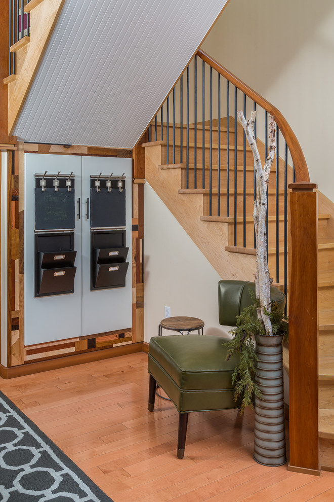 Example of a mid-sized transitional light wood floor foyer design with white walls