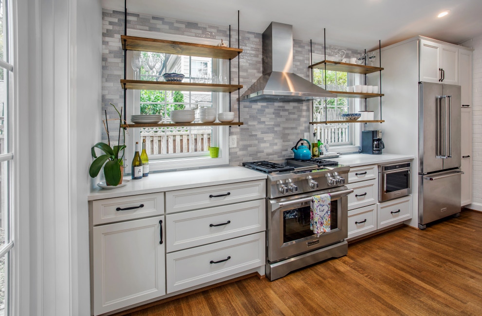 Mid-sized transitional single-wall eat-in kitchen in DC Metro with flat-panel cabinets, blue cabinets, quartz benchtops, blue splashback, glass sheet splashback, stainless steel appliances, with island and grey benchtop.