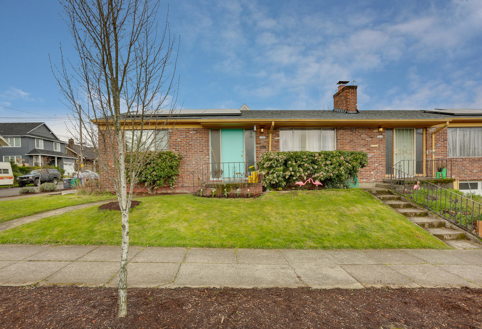 This is an example of a mid-sized midcentury one-storey brick red duplex exterior in Portland with a gable roof and a shingle roof.