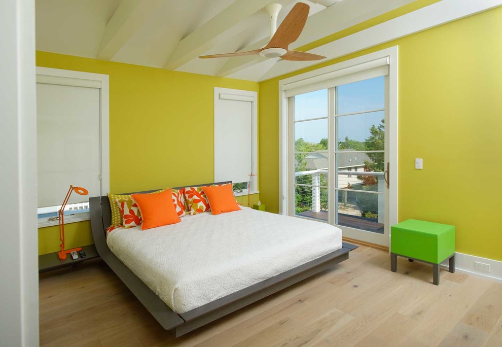 Photo of a mid-sized beach style master bedroom in Other with green walls, no fireplace and light hardwood floors.