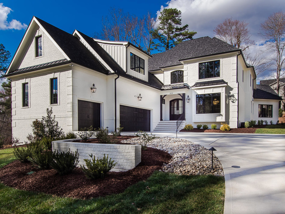 Mid-sized transitional two-storey stucco white house exterior in Raleigh with a clipped gable roof and a mixed roof.