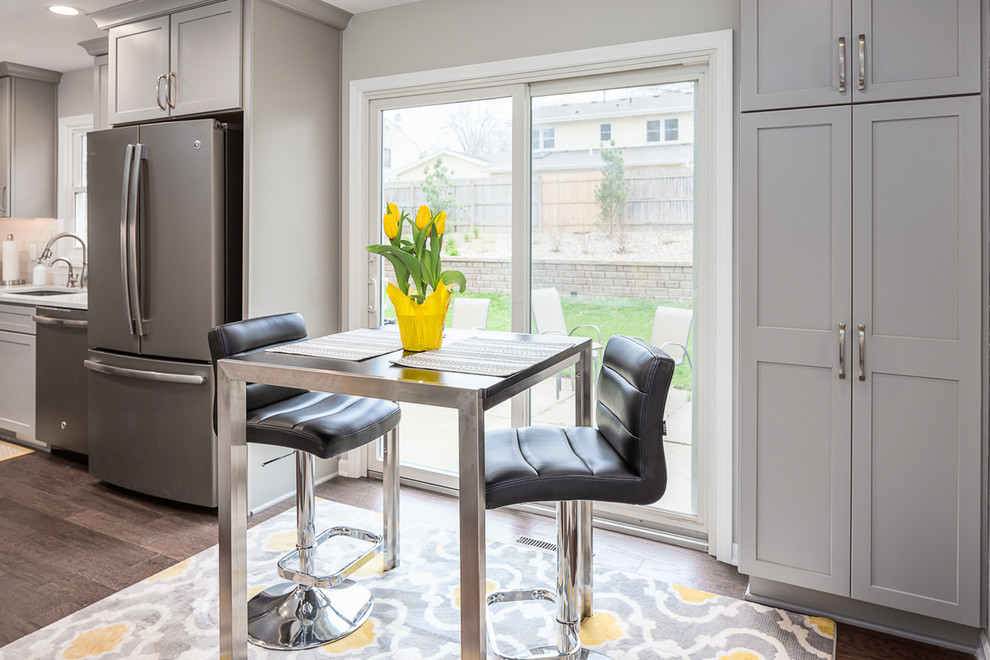 Eat-in kitchen - mid-sized transitional u-shaped laminate floor and brown floor eat-in kitchen idea with an undermount sink, recessed-panel cabinets, gray cabinets, quartzite countertops, white backsplash, subway tile backsplash, stainless steel appliances and no island