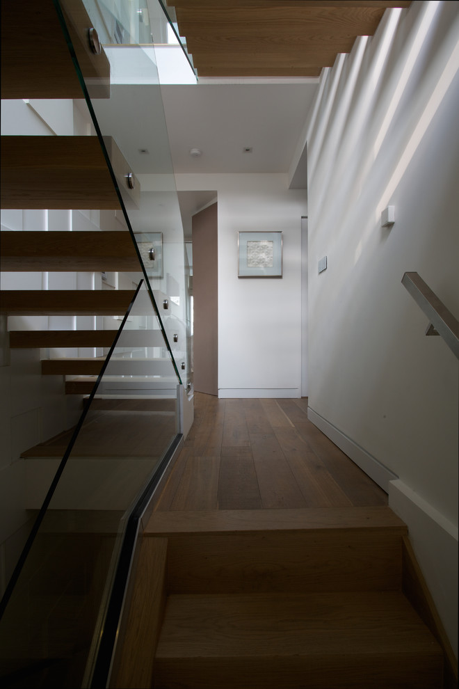 Mid-sized contemporary wood u-shaped staircase in London with wood risers.