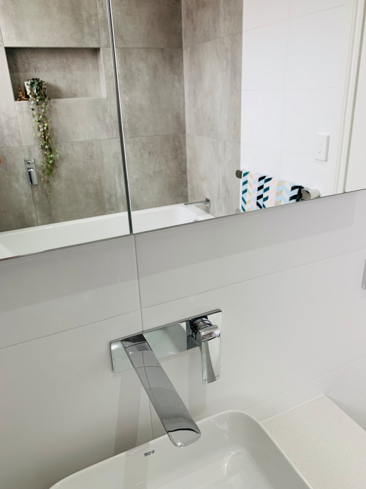 Idéer för att renovera ett mellanstort funkis grå grått en-suite badrum, med luckor med profilerade fronter, vita skåp, ett platsbyggt badkar, en dusch/badkar-kombination, flerfärgad kakel, porslinskakel, flerfärgade väggar, klinkergolv i porslin, ett fristående handfat, bänkskiva i kvarts, grått golv och dusch med gångjärnsdörr