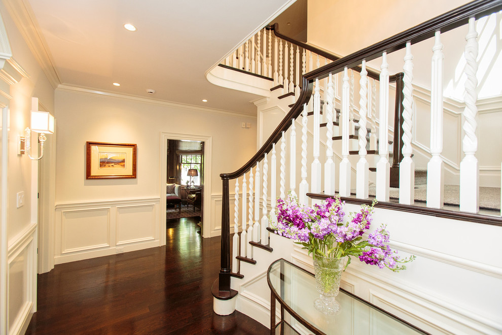 Photo of an expansive traditional wood u-shaped staircase in Boston with painted wood risers.