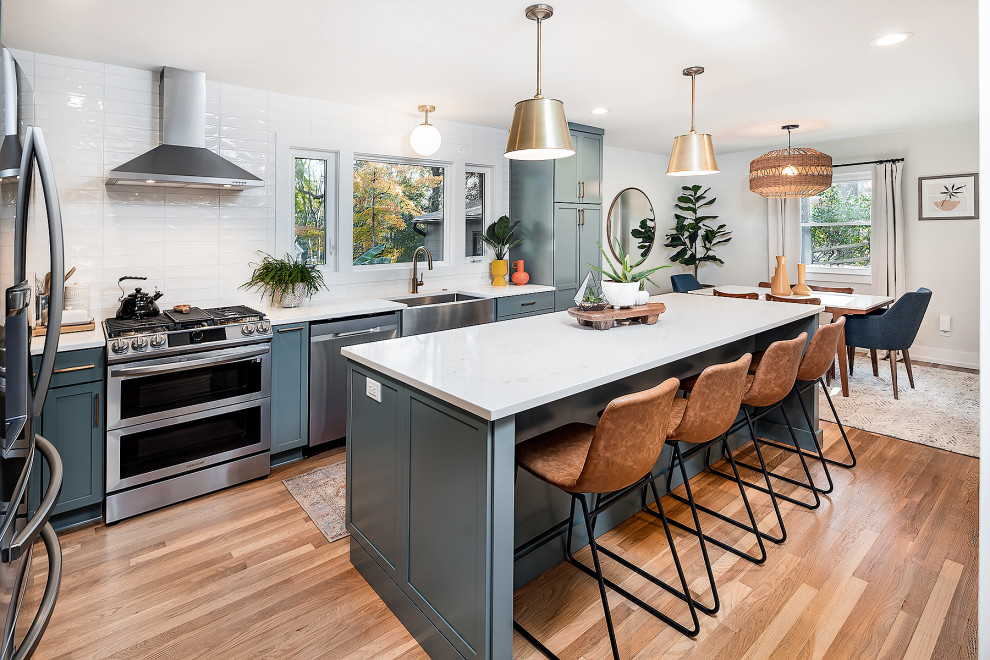 Photo of a large midcentury l-shaped eat-in kitchen in Charlotte with an undermount sink, shaker cabinets, turquoise cabinets, marble benchtops, white splashback, stainless steel appliances and with island.