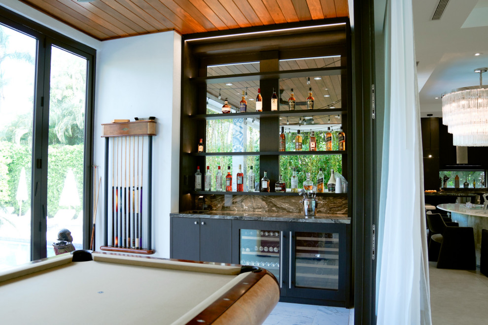 Ejemplo de bar en casa con fregadero lineal moderno con fregadero integrado, armarios tipo vitrina, puertas de armario negras y encimeras negras